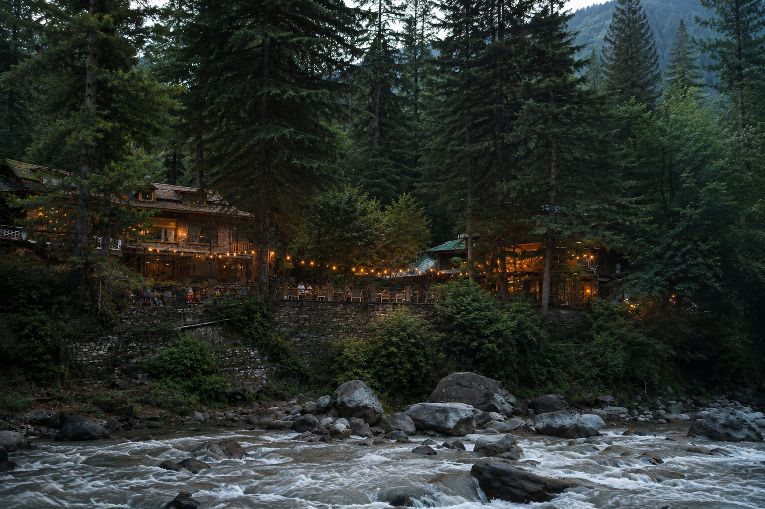 The Dankville lodge glowing at dusk beside the Parvati river